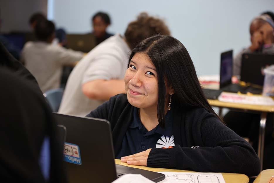 student in classroom smiling at camera